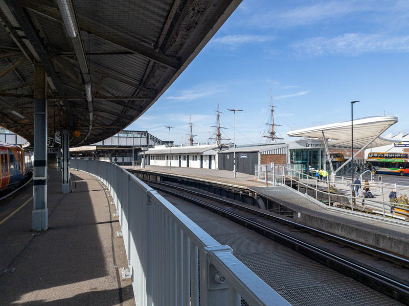 As we reach the canopy on
  platform 2 we can see the eastern end of platform 1 on the right and
  the bus station beyond.  The grating underneath where the track for
  platform 2 would be highlights the fact that we're on a pier.