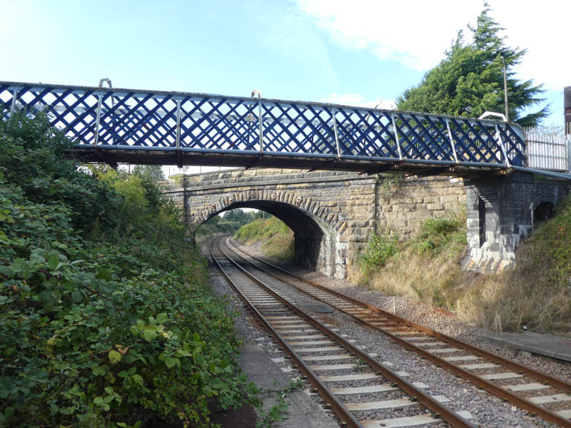 Looking west from the end of platform 2 at both the footbridge and road bridge beyond it