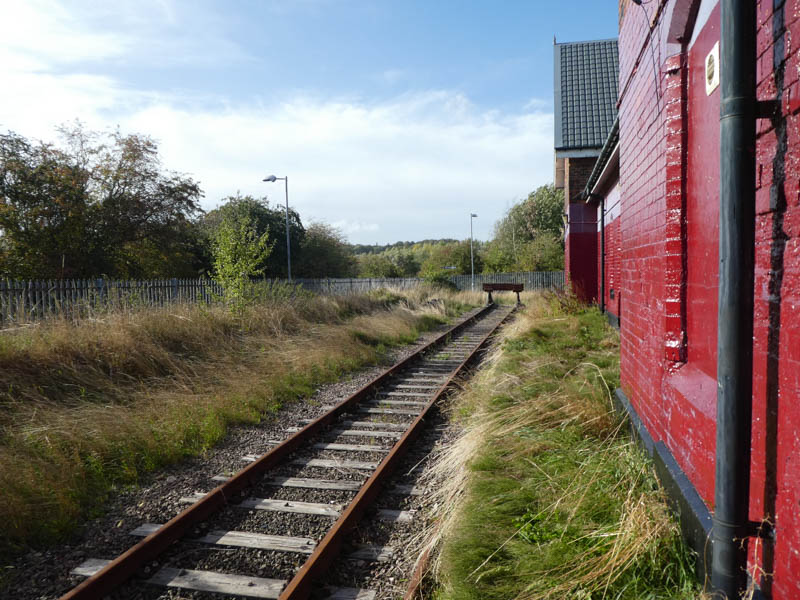 Looking along the disused platform edge behind platform 2's building