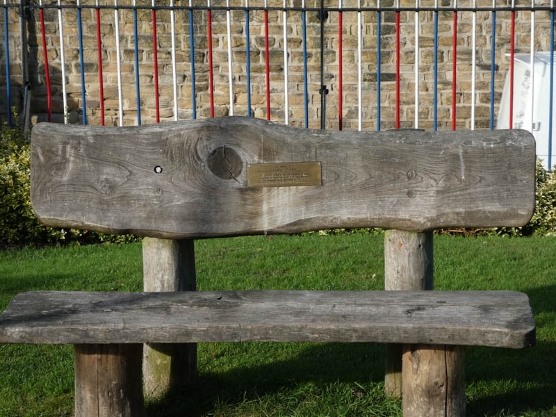 A wooden bench in the grassed area just north of platform 1