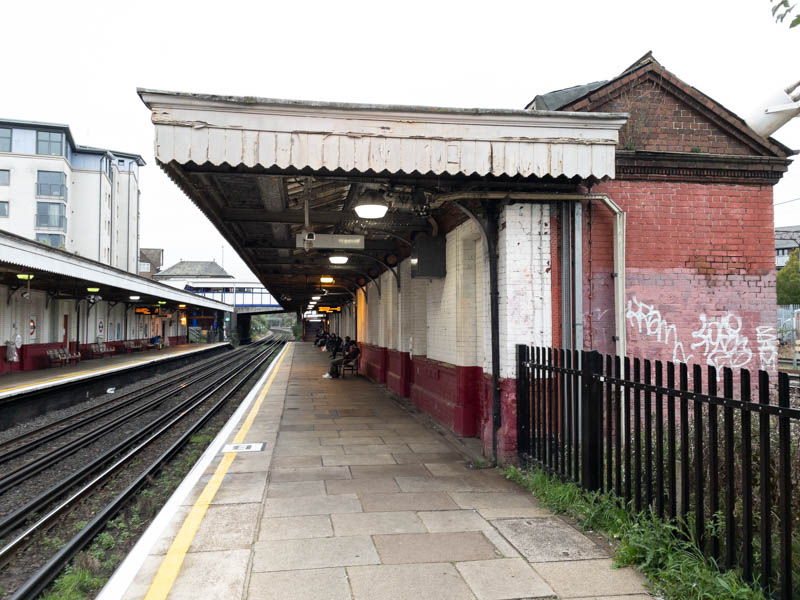 The wooden canopy on the up platform.  Although there's a building on the right, all of its doors and windows are boarded up.